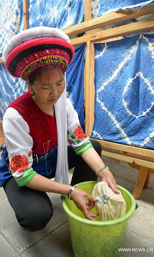 Artisan Duan Hua'ai works on a tie-dyeing product in Dali, southwest China's Yunnan Province, Nov. 15, 2016. As a traditional folk technique of the Bai ethnic group, tie dyeing was listed in 2006 into state-level intangible cultural heritages. The technique goes through three major steps: making knots, dipping and dyeing, and drying in the sun. The pattern of the cloth is simple and natural, which looks graceful, but not extravagant. Traditional tie-dyeing products are mostly inspired by local scenery and based on blue and white colors. (Xinhua/Ding Yiquan) 