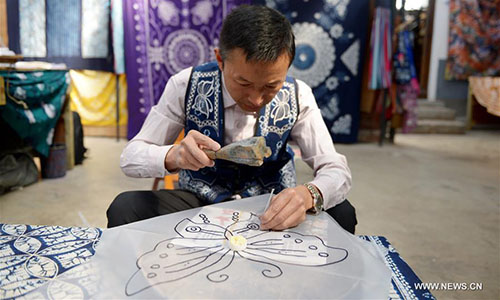 Artisan Duan Shukun works on a tie-dyeing product in Dali, southwest China's Yunnan Province, Nov. 15, 2016. As a traditional folk technique of the Bai ethnic group, tie dyeing was listed in 2006 into state-level intangible cultural heritages. The technique goes through three major steps: making knots, dipping and dyeing, and drying in the sun. The pattern of the cloth is simple and natural, which looks graceful, but not extravagant. Traditional tie-dyeing products are mostly inspired by local scenery and based on blue and white colors. (Xinhua/Li Yan) 