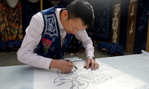 Artisan Duan Shukun works on a tie-dyeing product in Dali, southwest China's Yunnan Province, Nov. 15, 2016. As a traditional folk technique of the Bai ethnic group, tie dyeing was listed in 2006 into state-level intangible cultural heritages. The technique goes through three major steps: making knots, dipping and dyeing, and drying in the sun. The pattern of the cloth is simple and natural, which looks graceful, but not extravagant. Traditional tie-dyeing products are mostly inspired by local scenery and based on blue and white colors. (Xinhua/Li Yan) 