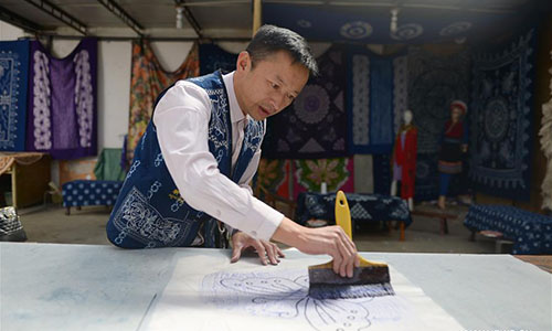 Artisan Duan Shukun works on a tie-dyeing product in Dali, southwest China's Yunnan Province, Nov. 15, 2016. As a traditional folk technique of the Bai ethnic group, tie dyeing was listed in 2006 into state-level intangible cultural heritages. The technique goes through three major steps: making knots, dipping and dyeing, and drying in the sun. The pattern of the cloth is simple and natural, which looks graceful, but not extravagant. Traditional tie-dyeing products are mostly inspired by local scenery and based on blue and white colors. (Xinhua/Li Yan) 