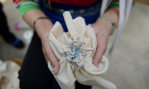 Artisan Duan Hua'ai shows the cloth of a tie-dyeing product in Dali, southwest China's Yunnan Province, Nov. 15, 2016. As a traditional folk technique of the Bai ethnic group, tie dyeing was listed in 2006 into state-level intangible cultural heritages. The technique goes through three major steps: making knots, dipping and dyeing, and drying in the sun. The pattern of the cloth is simple and natural, which looks graceful, but not extravagant. Traditional tie-dyeing products are mostly inspired by local scenery and based on blue and white colors. (Xinhua/Ding Yiquan) 