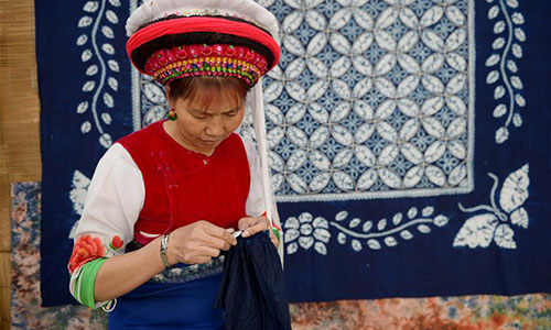 Artisan Duan Hua'ai works on a tie-dyeing product in Dali, southwest China's Yunnan Province, Nov. 15, 2016. As a traditional folk technique of the Bai ethnic group, tie dyeing was listed in 2006 into state-level intangible cultural heritages. The technique goes through three major steps: making knots, dipping and dyeing, and drying in the sun. The pattern of the cloth is simple and natural, which looks graceful, but not extravagant. Traditional tie-dyeing products are mostly inspired by local scenery and based on blue and white colors. (Xinhua/Ding Yiquan) 