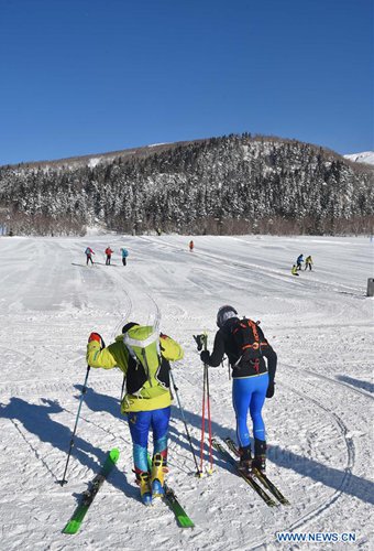 Tourists ski around the Tianchi Lake on the Changbai Mountain, in northeast China's Jilin Province, Dec. 15, 2016. (Xinhua/Lin Hong)