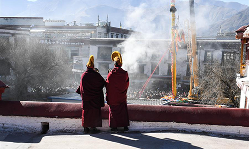 Monks perform religious ceremony at a pole near the Jokhang Temple in Lhasa, capital of southwest China's Tibet Autonomous Region, Feb. 8, 2017. As the Tibetan New Year draws near, prayer flags tied on the five poles surrounding the Jokhang Temple have been replaced by new ones in accordance with Tibetan tradition. (Xinhua/Purbu Zhaxi)