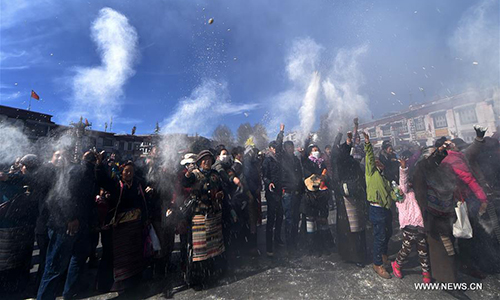 Devotees perform religious ceremony at a pole near the Jokhang Temple in Lhasa, capital of southwest China's Tibet Autonomous Region, Feb. 8, 2017. As the Tibetan New Year draws near, prayer flags tied on the five poles surrounding the Jokhang Temple have been replaced by new ones in accordance with Tibetan tradition. (Xinhua/Chogo)