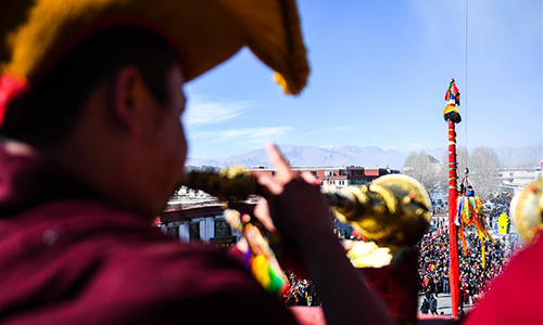 Monks perform religious ceremony at a pole near the Jokhang Temple in Lhasa, capital of southwest China's Tibet Autonomous Region, Feb. 8, 2017. As the Tibetan New Year draws near, prayer flags tied on the five poles surrounding the Jokhang Temple have been replaced by new ones in accordance with Tibetan tradition. (Xinhua/Purbu Zhaxi)