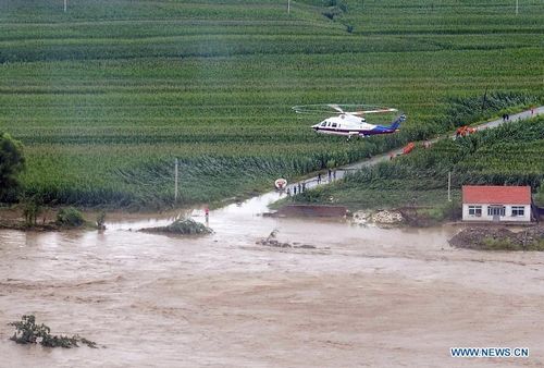 A helicopter flies to rescue trapped people in Liaoyang, Northeast China's Liaoning Province, August 4, 2012. Two helicopters of Beihai Rescue Flying Squad has rescued 24 people trapped by the rain-triggered flood in Liaoyang till 6 pm Saturday. Photo: Xinhua