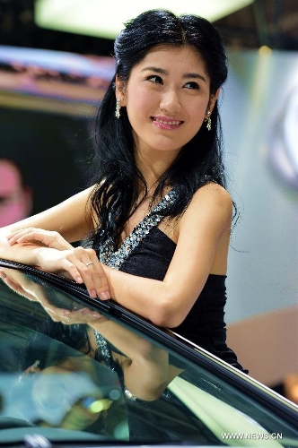 A model poses for photos with a sedan at Fuzhou Auto Fair in Fuzhou, capital of southeast China's Fujian Province, April 29, 2013. (Xinhua/Zhang Guojun) 