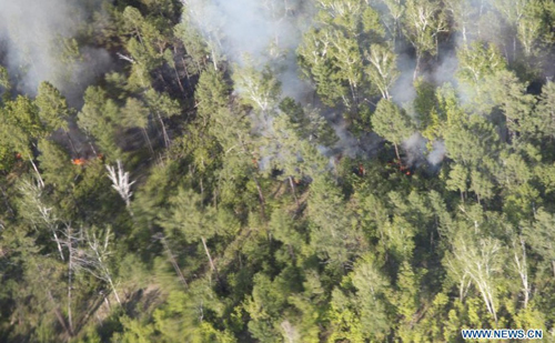 Smoke and fire are seen in the Greater Hinggan Mountains in northeast China's Heilongjiang Province, June 2, 2012. A forest fire that started Saturday morning on a nature reserve in northeast China's Heilongjiang Province was put out at around 8 pm, according to the local forest fire prevention headquarters. Photo: Xinhua