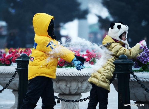 Children play with snow in Harbin, capital of northeast China's Heilongjiang Province, Jan. 20, 2013. The temperature rise in Harbin enabled citizens to play with snow and ice in the outdoors. (Xinhua/Wang Kai)  