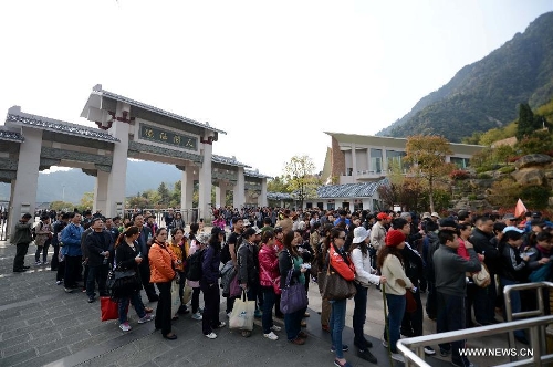 Tourists line up to take cable cars while visiting the Sanqing Mountain in east China's Jiangxi Province, April 13, 2013. The scenic area of Sanqing Mountain entered a peak tourist season as temperature rises recently. (Xinhua/Zhou Ke) 