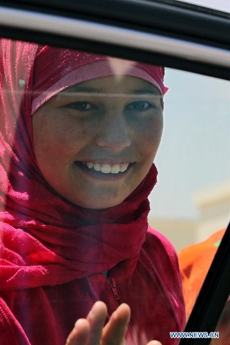 A Syrian refugee girl smiles at the Mrajeeb Al Fhood refugee camp, 20 km (12.4 miles) east of the city of Zarqa, April 29, 2013. The Mrajeeb Al Fhood camp, with funding from the United Arab Emirates, has received about 2500 Syrian refugees so far, according to the Red Crescent Society of the United Arab Emirates. (Xinhua/Mohammad Abu Ghosh) 