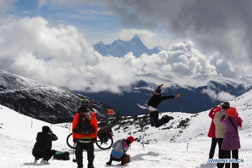 Photo taken on April 15, 2013 shows travellors taking photos of the Mount Namcha Barwa in Nyingchi Prefecture, southwest China's Tibet Autonomous Region. (Xinhua/Wen Tao) 