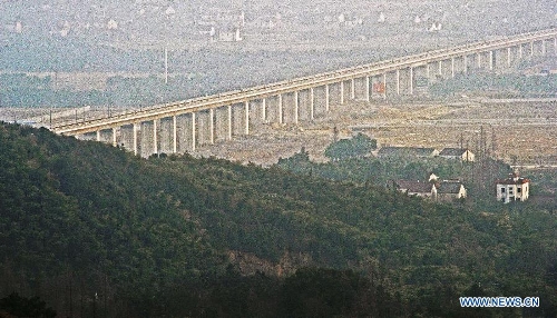 A viaduct is seen over farmland in Huzhou, east China's Zhejiang Province, Feb. 28, 2013. The 150-kilometer Hangzhou-Ningbo high-speed railway linking Hangzhou and Ningbo, two hub cities in Zhejiang, commenced its integration test here on Friday. Once put into operation on July 2013 as expected, the high-speed railway that designed at a top speed of 350km/h, would reduce the travel time to 36 minitues, a quarter time of the current two-hour journey. (Xinhua/Tan Jin)  