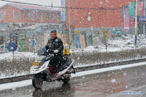 A citizen rides in snow in Baishan City, northeast China's Jilin Province, April 9, 2013. (Xinhua/Zhang Nan) 