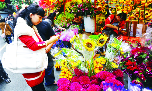 Consumers shop for flowers in Guangzhou, capital of South China's Guangdong Province on Thursday. Sales of flowers have picked up with the Spring Festival holidays coming closer. As this year's Valentine's Day falls during the holidays, many consumers have already started to book flowers. Roses are priced at around 10 yuan ($1.60) each at present, but the price could surge to 15 yuan on Valentine's Day. Photo: CFP