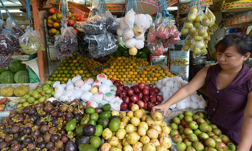 An Indonesian vendor arranges fruit at a traditional market in Jakarta on Monday. Food ingredients quickened Indonesia's inflation in March to 5.9 percent year-on-year, surpassing the central bank's target range of 5.5 percent, the statistics office said Monday. Photo: AFP