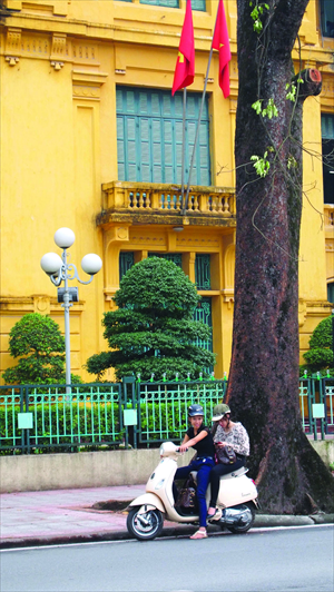 Young people ride a scooter in Hanoi.
