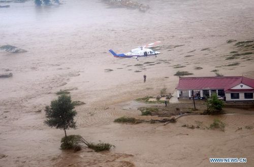 A trapped person is rescued by a helicopter in Liaoyang, Northeast China's Liaoning Province, August 4, 2012. Two helicopters of Beihai Rescue Flying Squad has rescued 24 people trapped by the rain-triggered flood in Liaoyang till 6 pm Saturday. Photo: Xinhua