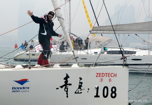 China's Guo Chuan gestures on his boat in Qingdao, east China's Shandong Province, April 5, 2013. Guo sailed back home on Friday morning to become the first Chinese to successfully circumnavigate the globe singlehanded. Aboard his Class40 yacht, 48-year-old Guo travelled about 21,600 nautical miles in 138 days before he returned to his hometown of Qingdao, where he set off on November 18 last year. (Xinhua/Li Ziheng)