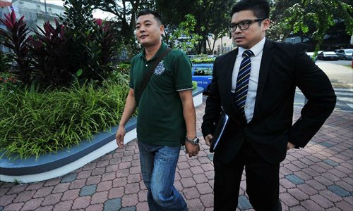 Chinese bus driver Liu Xiangying (L) attends court proceedings held at Subordinate Court in Singapore, December 12, 2012. Four Chinese bus drivers charged with instigating illegal strike attended a court hearing in Singapore Wednesday. A total of 171 Chinese bus drivers took medical leave on November 26 in protest against inequitable pay rises by local public transport operator SMRT, and 88 of them stayed away from work the following day. Five drivers were arrested and charged, while 29 others had their work permits revoked and deported to China. Out of the arrested, Bao Fengshan was sentenced to six weeks in jail, and the remaining four charged with instigating an illegal strike were released on bail. Photo: Xinhua