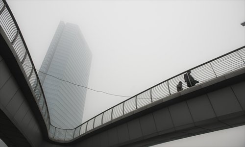 A building is obscured by smog in Beijing, the capital of China, on January 29, 2013. The National Meteorological Center (NMC) issued a code-blue alert on January 27 as the smoggy weather forecast for the following two days would cut visibility and worsen air pollution in some central and eastern Chinese cities. Photo: Li Hao/GT