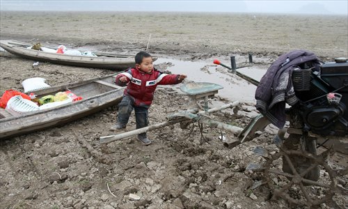 Six-year-old Gao Zhiqiang plays with an idle amphibious tractor.Photo: CFP