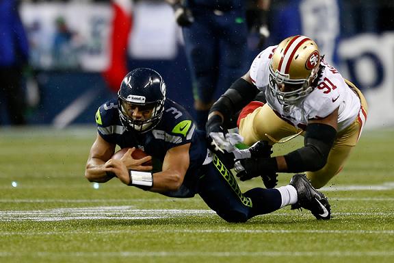 Russell Wilson (left) of the Seattle Seahawks dives for yards against Ray McDonald of the San Francisco 49ers on Sunday. Photo: AFP