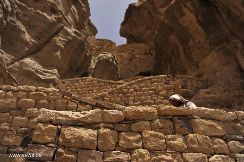 A Yemeni walks on a path that leads to the Thula Fort at the historical city of Thula, 45 km north of Sanaa, Yemen, on May 12, 2013. Thula Fort is one of 20 nominees for the 2013 Aga Khan Award for Architecture which is given every three years to projects that set new standards of excellence in architecture, planning practices, historic preservation and landscape architecture, in which Muslims have a significant presence. Thula boasts an impressive collection of stone buildings that date back to the 1st millennium BCE. The Thula fort was threatened by the disruption that might ensue from the construction of a road. However, the Yemeni government has undertaken a series of historic preservation projects to protect cultural assets, including rebuilding the walls of burial grounds, watch towers, paths and waterways, and repairing the cistern that remains in use to this day.(Xinhua/Mohammed Mohammed)