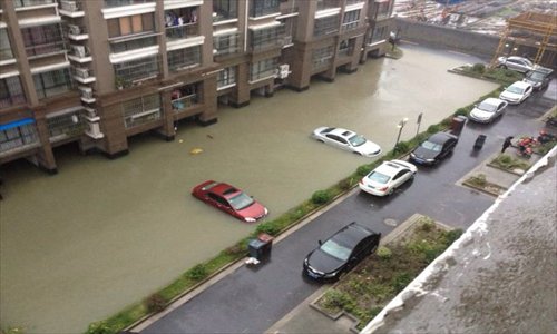 Two cars remain in this flooded parking lot at a neighborhood in Songjiang district. Photo: Courtesy of Meng Yuyi