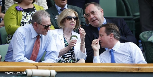 Jacques Rogge (L), president of the International Olympic Committee, talks with British Prime Minister David Cameron (R) during the men's singles final with Novak Djokovic of Serbia on day 13 of the Wimbledon Lawn Tennis Championships at the All England Lawn Tennis and Croquet Club in London, Britain, July 7, 2013. Andy Murray on Sunday won his first Wimbledon title and ended Britain's 77-year wait for a men's champion with a 6-4 7-5 6-4 victory over world number one Novak Djokovic. (Xinhua/Wang Lili) 