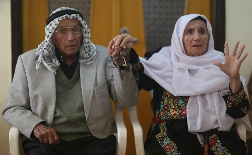 Abu Hafez and his wife show the keys of their former house they displaced since 1948, in Al-Jalazoun Refugee camp near Ramallah in the West Bank on May 14, 2013. Palestinians are preparing for Nakba Day on May 15, marking thousands of Palestinians that were forced to leave their homes during the Arab-Israeli war in 1948. (Xinhua/Fadi Arouri) 