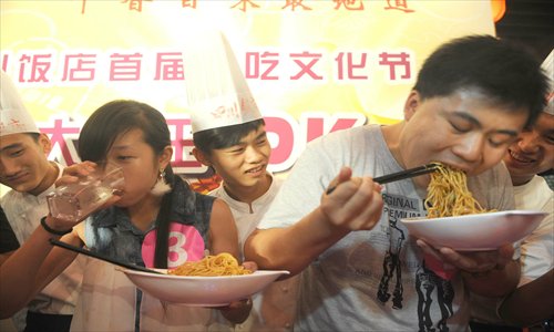 At a noodle eating competition held by a Sichuan food restaurant in Beijing on Monday, Chen Fang, the only woman brave enough to challenge the men, won applause from the audience. Different from similar competitions, this contest crowned a champion based on the time one takes to finish about 250 grams of noodles instead of measuring the amount of noodles one can devour in certain period of time. However, the gender gap remained as a man ended up being victorious. Photo: CFP