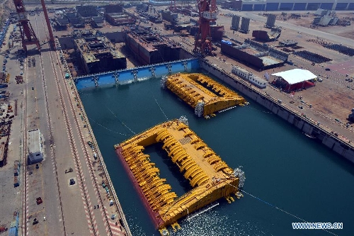 Photo taken on July 3, 2013 shows buoys of the newly-built deep-sea engineering equipment in Qingdao, east China's Shandong Province. With four sets of buoys and 16 sets of foundations, the deep-sea engineering equipment, the world's largest of this kind, was built and delivered by Wuchang Shipbuilding Industry Co., Ltd. to Petrobras as part of the Sapinhoa-Lula NE BSR Buoys & Foundations Project, which will be installed in an offshore oilfield in Brazil to work for a period of 27 years. The equipment is able to fit in deeper and more complicated marine environment and has extensively enlarged the scope of offshore oil exploitation, said Victor Bomfim, senior vice president of the project contractor Subsea 7 S.A. (Xinhua/Wan Houde) 