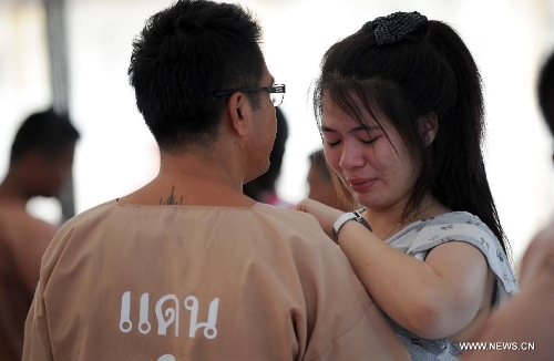 An unshackled prisoner embraces his daughter at Central Bangkwang Prison in Nonthaburi Province, Thailand, on May 15, 2013. More than 500 prisoners who committed serious crimes have had the handcuffs and foot shackles removed in Thailand. (Xinhua/Gao Jianjun) 