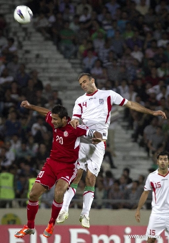 Jalal Hosseini (R) of Iran vies with Abbas Atwi of Lebanon during their 2014 World Cup Qualification Asia match at Azadi stadium in Tehran, Iran, June 11, 2013. Iran won 4-0. (Xinhua/Ahmad Halabisaz) 