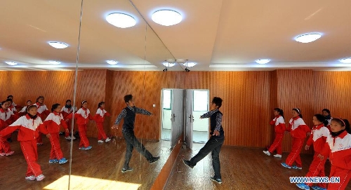 A teacher of the Tibetan ethnic group directs his students to practise folk dance at No. 1 Primary School of Deqin County in Diqing Tibetan Autonomous Prefecture, southwest China's Yunnan Province, March 12, 2013. A total of 1,260 pupils, most of whom are of the Tibetan ethnic group, study at this school, which was founded in September 2012. Pupils here are offered free meals and lodging. (Xinhua/Lin Yiguang) 