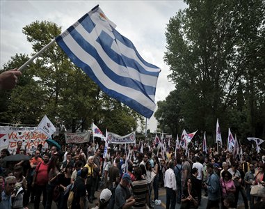 A man waves greek flags while thousands rally outside the Greek State broadcaster ERT headquarters in Athens, during a 24-hour strike to support ERT employees and the state television network on Thursday. Photo: AFP 