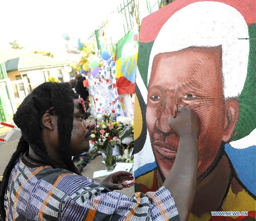 Painter Lebani Sirenje paints a portrait outside the hospital where South Africa's anti-apartheid icon Nelson Mandela is treated in Pretoria, South Africa, to pray for Mandela, June 26, 2013. South Africa's President Zuma said on Wednesday that Mandela's condition 