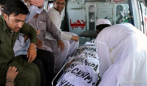 Pakistanis gather around the body of Sadiq Zaman Khattak, a candidate for a National Assembly seat of the ethnic Pashtoon 