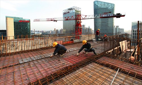 Construction workers seal New York University Shanghai's roof atop a concrete and steel frame Thursday. Located in the Lujiazui Financial and Economic Zone, the 65,000-square-meter complex will feature a 15-floor main building with a six-floor annex. Classes will begin in September 2013. Photo: CFP