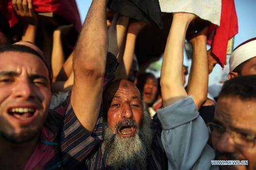 Supporters of ousted Egyptian President Mohamed Morsi carry the coffins of people killed a day before during the clashes outside the Republican Guard headquarter, in Nasr City, Cairo, Egypt, July 6, 2013. (Xinhua/Wissam Nassar)