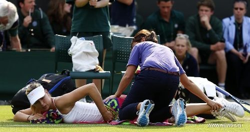 Maria Sharapova of Russia receives medical treatment during the second round of women's singles against Michelle Larcher De Brito of Portugal on day 3 of the Wimbledon Lawn Tennis Championships at the All England Lawn Tennis and Croquet Club in London, Britain on June 26, 2013. Maria Sharapova lost 0-2. (Xinhua/Wang Lili) 