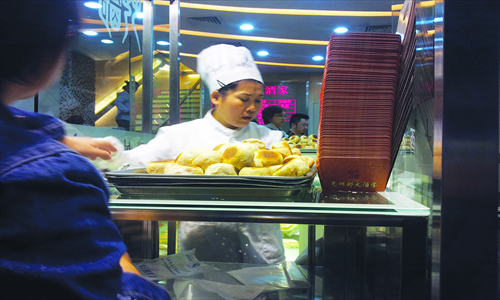 a cook takes out a fresh tray of meat buns Photo: Courtesy of Kyle J. Mitchell