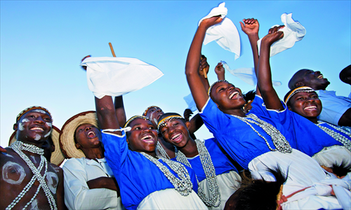 Young dancers cheer for US Secretary of State Hillary Clinton as she visits Reach Out Mbuya, a health clinic, in Kampala, Uganda on August 3, 2012. Photo: AFP 