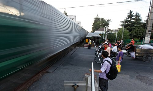 Pedestrians and cyclists wait at the crossing on Songhuajiang Road near Jungong Road as a freight train passes. Photo: Yang Hui/GT