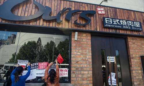 People paste pro-China slogans and national flags on the windows to protect restaurants selling Japanese cuisine at Lucky Street, near the Japanese embassy on Saturday. Photo: Li Hao/GT