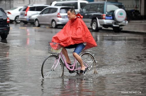 A man rides bicycle on a flooded road in Taiyuan, capital of North China's Shanxi Province, July 31, 2012. A downpour hit the city on Tuesday morning and caused urban waterlogging. Photo: Xinhua