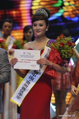 Gan Quan, the third-prize winner, shows the certificate during the final match of the 2013 Miss Tourism International (Guizhou) in Guiyang, capital of southwest China's Guizhou Province, April 9, 2013. The final match, with the participation of 31 competitors, closed here Tuesday. (Xinhua/Ou Dongqu)