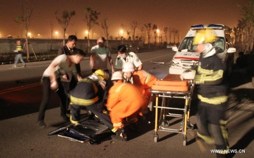 Rescuers work at the accident site after a car with eight passengers collided with a trailer in Wenzhou City, east China's Zhejiang Province, May 12, 2013. Seven people were killed and one other injured in the accident, which ocurred at midnight on Saturday. (Xinhua)